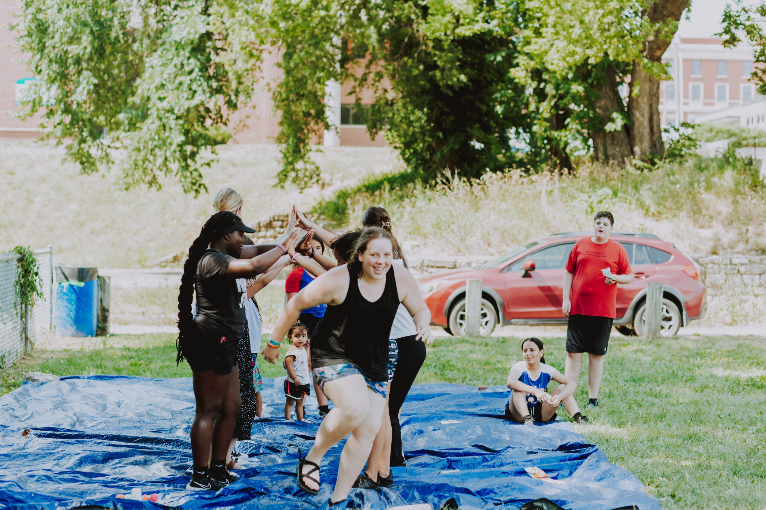 Short-term missionaries playing in a field with children during a Kansas City Dream Center outreach.