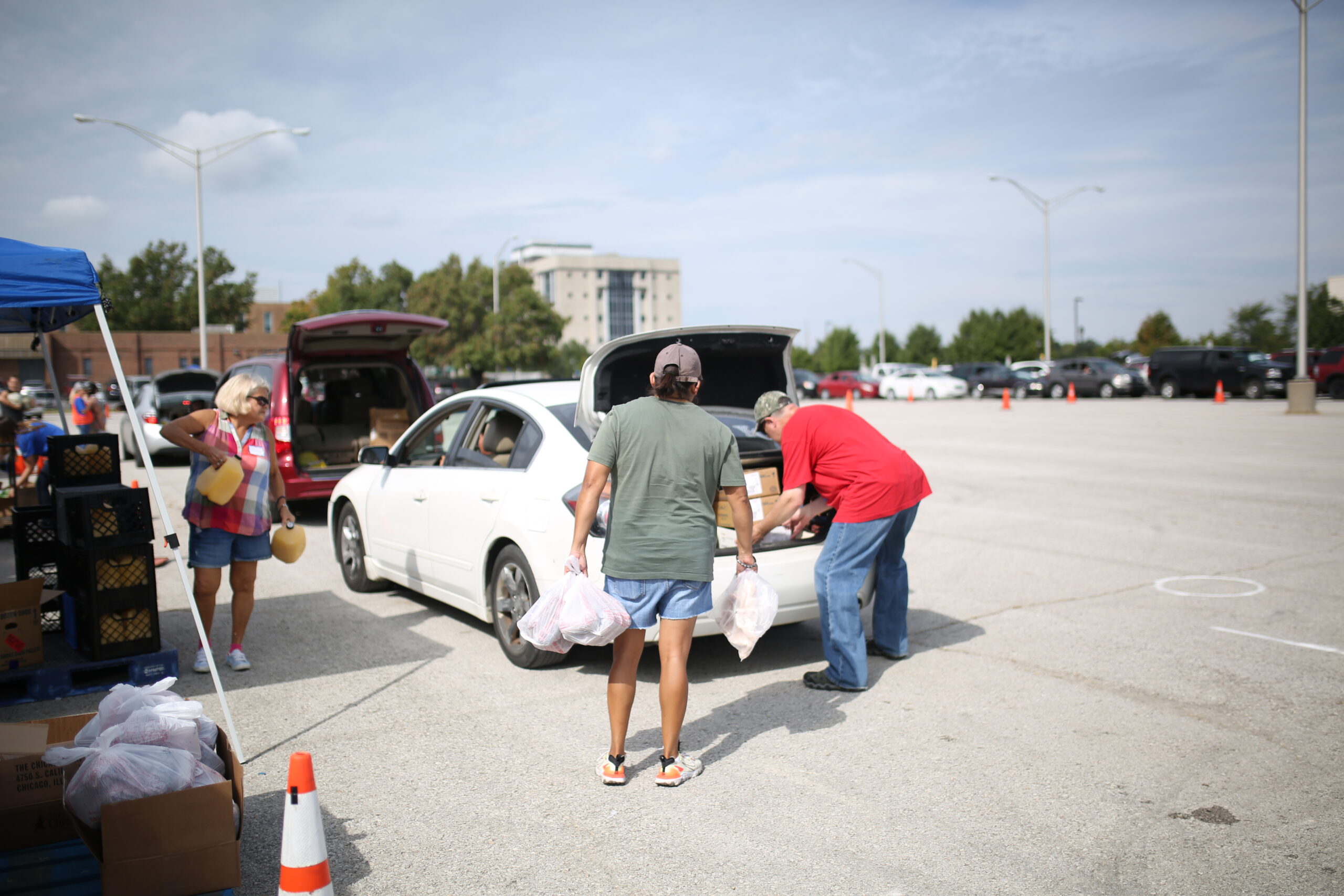 Volunteer loading food into a community member's car at a Mobile Food Distribution event.